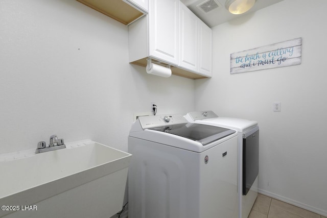 clothes washing area with visible vents, light tile patterned floors, cabinet space, independent washer and dryer, and a sink