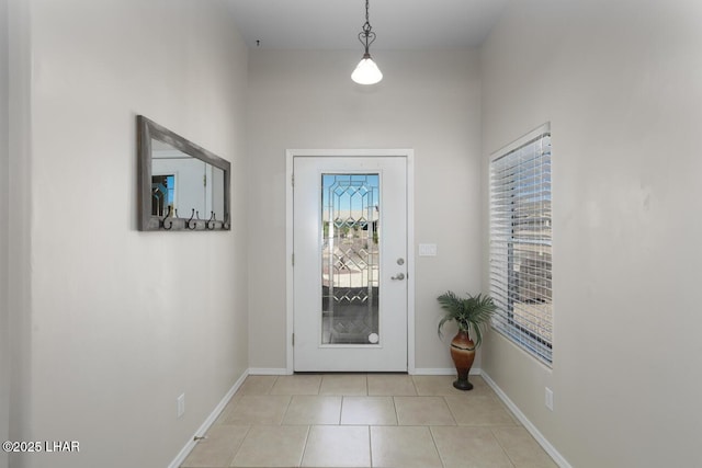 entryway featuring light tile patterned floors, baseboards, and plenty of natural light