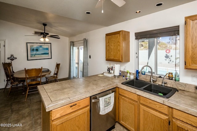 kitchen featuring plenty of natural light, a sink, a peninsula, and stainless steel dishwasher