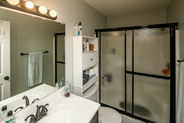 bathroom featuring toilet, a shower stall, and vanity