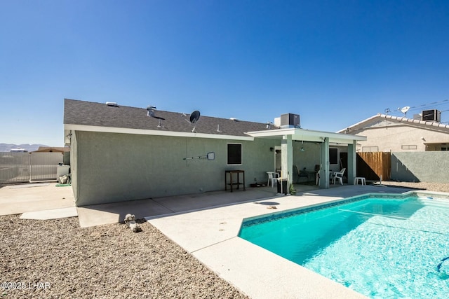 back of house featuring a fenced in pool, a patio, stucco siding, central AC unit, and fence