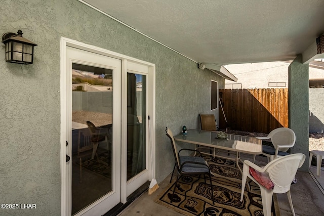 view of patio with outdoor dining space and fence