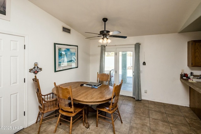 dining room with baseboards, visible vents, a ceiling fan, dark tile patterned flooring, and lofted ceiling