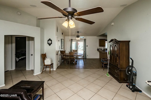 living area featuring vaulted ceiling, light tile patterned flooring, and baseboards