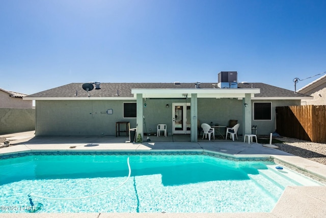 view of swimming pool featuring a fenced in pool, a patio area, fence, and central AC unit