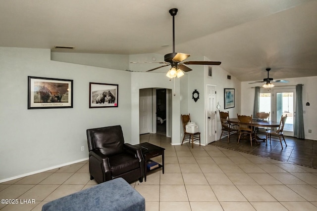 living room with lofted ceiling, ceiling fan, light tile patterned flooring, visible vents, and baseboards