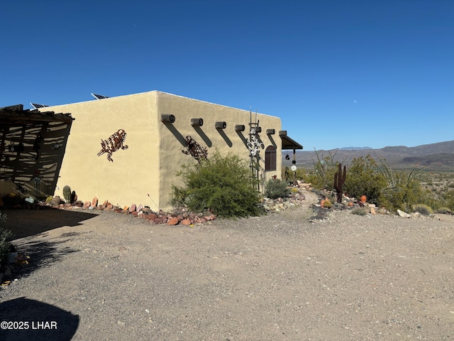 view of side of property featuring a mountain view and stucco siding