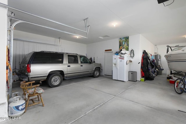 garage featuring white fridge with ice dispenser