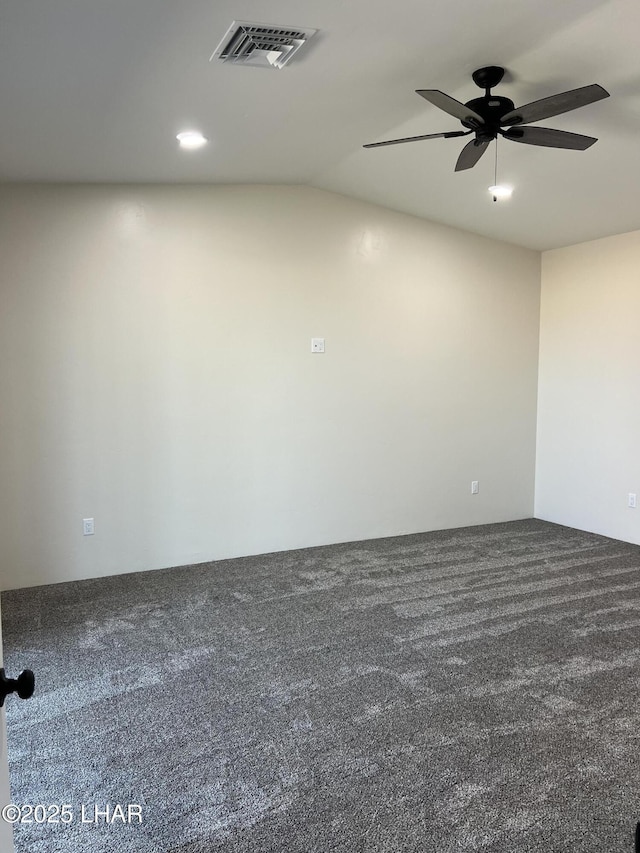 carpeted spare room with visible vents and a ceiling fan