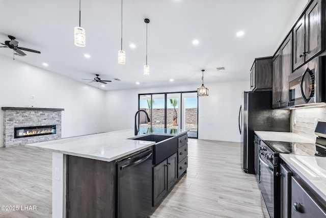 4801 N Diana Ave, Lake Havasu City, AZ 86404 - kitchen with black appliances, a stone fireplace, ceiling fan, a sink, and recessed lighting