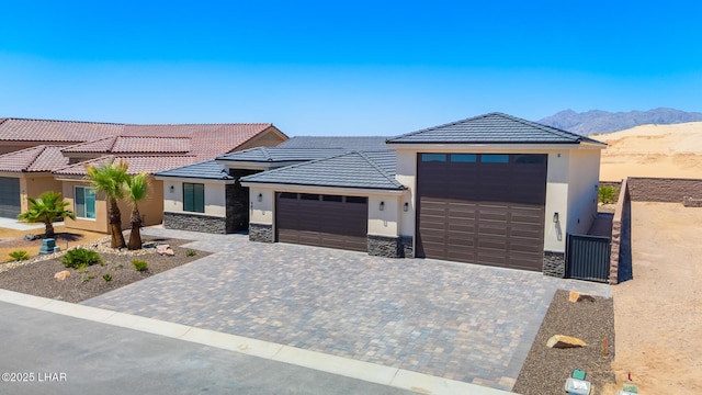 4801 N Diana Ave, Lake Havasu City, AZ 86404 - view of front of house with stone siding, stucco siding, an attached garage, a mountain view, and a tiled roof