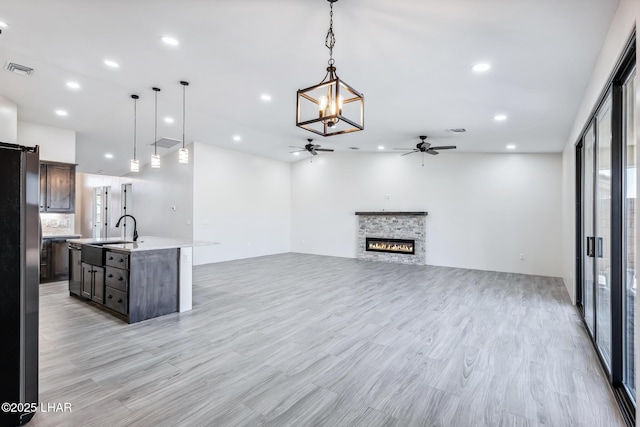 4801 N Diana Ave, Lake Havasu City, AZ 86404 - unfurnished living room with a ceiling fan, a fireplace, a sink, light wood-style floors, and recessed lighting