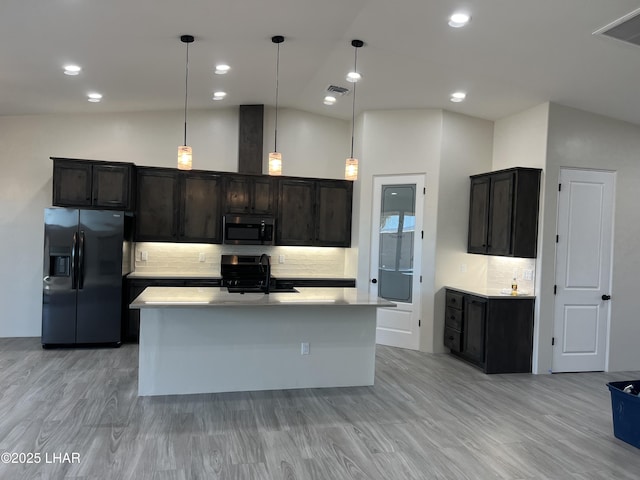 kitchen with stainless steel microwave, a sink, visible vents, black refrigerator with ice dispenser, and range