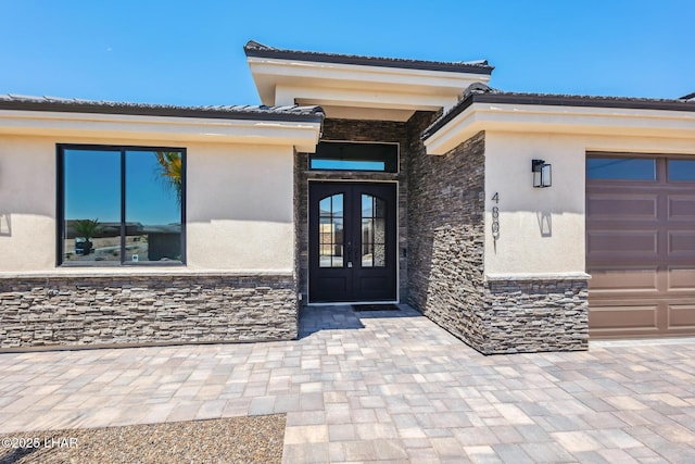 4801 N Diana Ave, Lake Havasu City, AZ 86404 - view of exterior entry featuring french doors, stone siding, stucco siding, and an attached garage