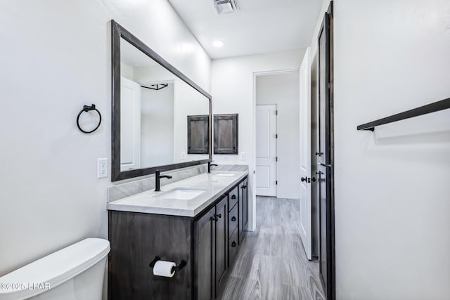 4801 N Diana Ave, Lake Havasu City, AZ 86404 - bathroom with double vanity, toilet, wood finished floors, and recessed lighting