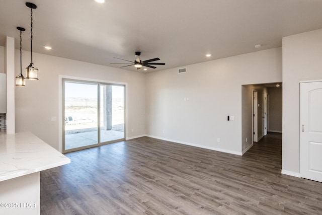 unfurnished living room with ceiling fan and dark hardwood / wood-style flooring