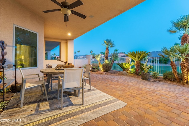 patio terrace at dusk featuring ceiling fan