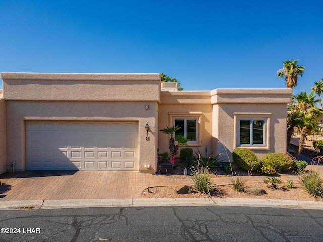 pueblo-style home featuring a garage