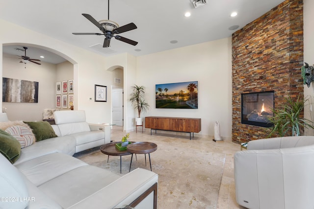 living room with ceiling fan and a large fireplace