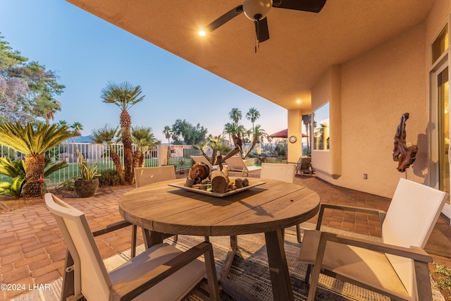 patio terrace at dusk featuring ceiling fan