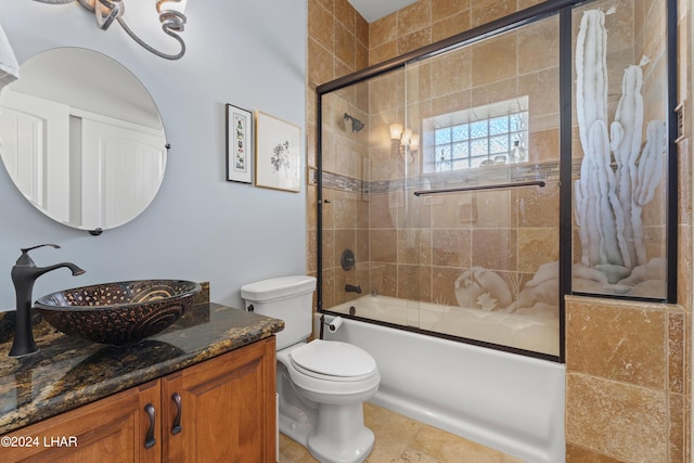 full bathroom with toilet, vanity, and shower / bath combination with glass door