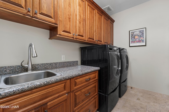 laundry area featuring cabinets, washer and clothes dryer, and sink