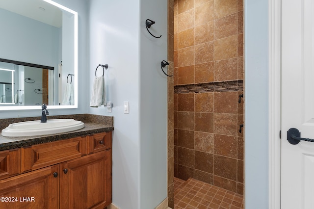 bathroom featuring tiled shower and vanity