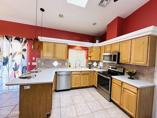 kitchen with a peninsula, a sink, visible vents, light countertops, and appliances with stainless steel finishes