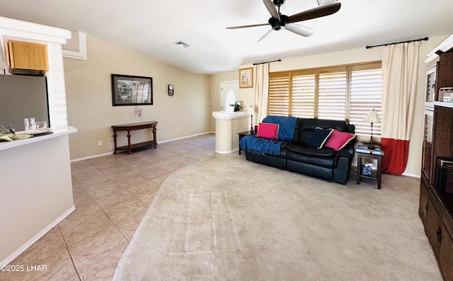 living area with a ceiling fan, lofted ceiling, baseboards, and light tile patterned floors