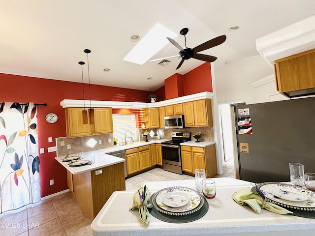 kitchen with a skylight, visible vents, appliances with stainless steel finishes, light countertops, and light tile patterned flooring