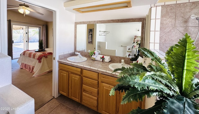 full bathroom featuring double vanity, tile patterned floors, a sink, and connected bathroom