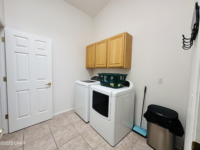 washroom with light tile patterned flooring, washing machine and clothes dryer, cabinet space, and baseboards