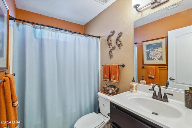 bathroom featuring a shower with shower curtain, toilet, vanity, and a textured wall