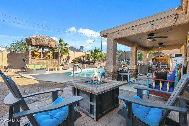 view of patio / terrace with a fenced in pool, a fire pit, a fenced backyard, and a ceiling fan