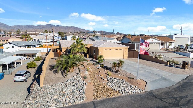 view of front of home featuring stucco siding, a mountain view, a residential view, concrete driveway, and an attached garage