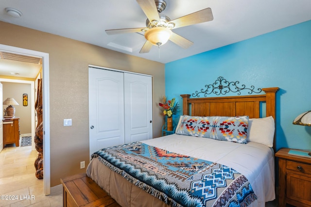 bedroom featuring light tile patterned floors, visible vents, a closet, and ceiling fan