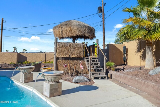 view of patio with stairs, fence, and a fenced in pool