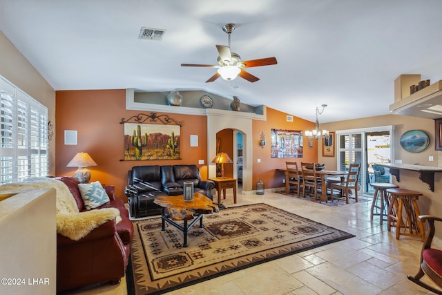 living room featuring visible vents, ceiling fan with notable chandelier, stone tile floors, arched walkways, and lofted ceiling