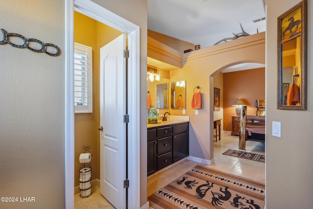 bathroom featuring tile patterned floors, visible vents, ensuite bathroom, baseboards, and vanity