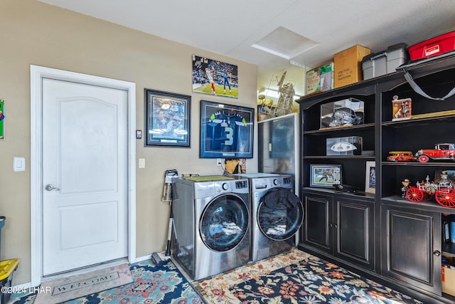 laundry area with cabinet space, attic access, and washing machine and clothes dryer