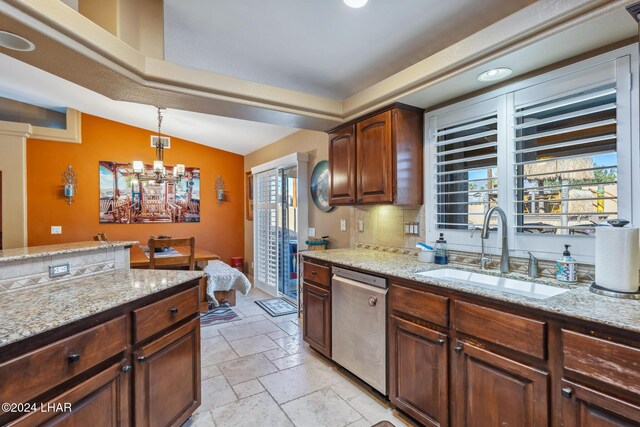 kitchen featuring a sink, plenty of natural light, dishwasher, and stone tile flooring