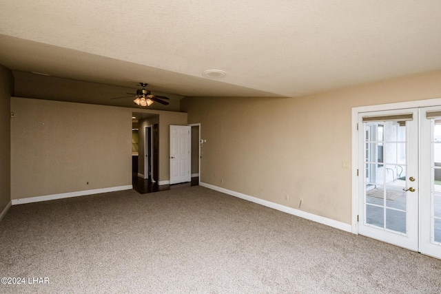 spare room featuring carpet, ceiling fan, and french doors