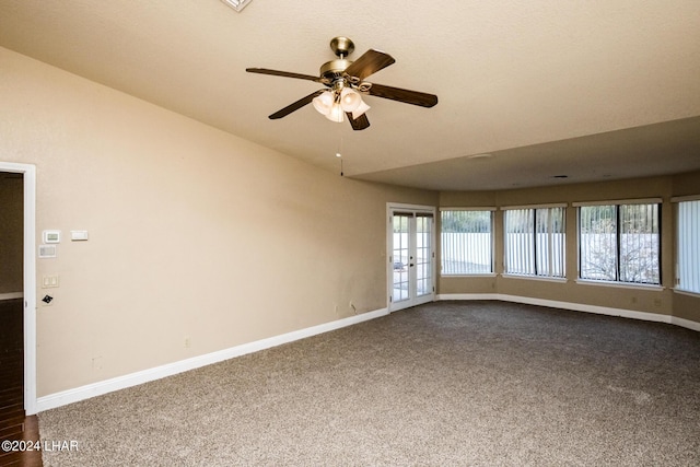 carpeted spare room with ceiling fan and french doors