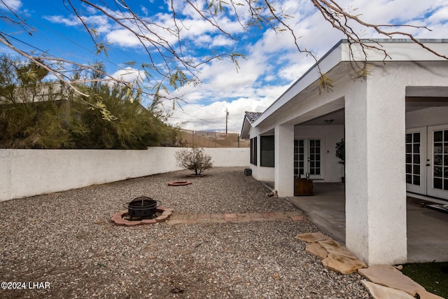 view of yard with french doors, a patio, and a fire pit