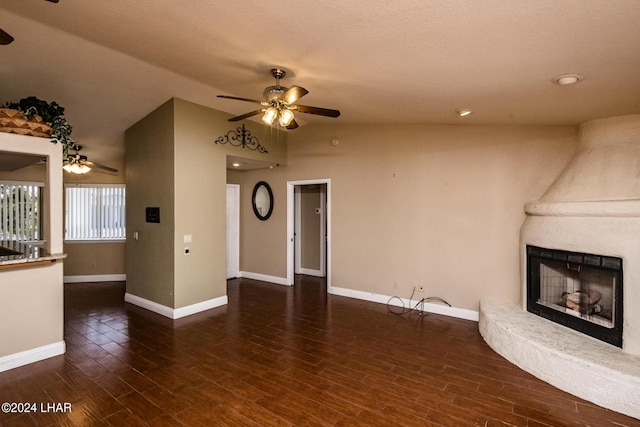 unfurnished living room featuring dark wood-type flooring, a large fireplace, ceiling fan, and vaulted ceiling