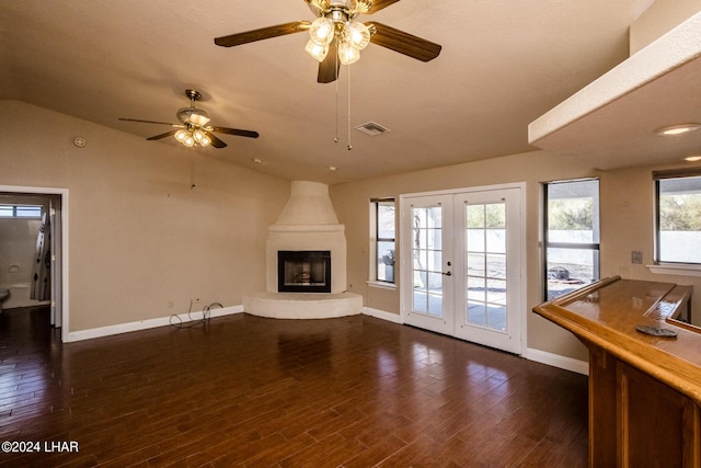 unfurnished living room featuring lofted ceiling, dark wood-type flooring, a fireplace, and french doors