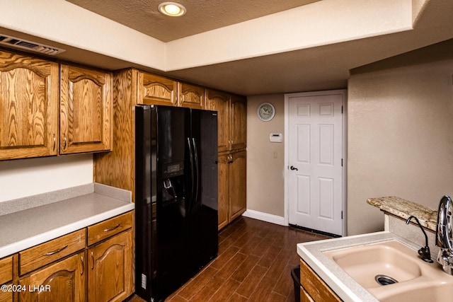 kitchen with sink, a textured ceiling, dark hardwood / wood-style floors, and black refrigerator with ice dispenser