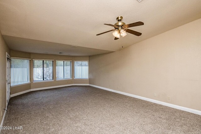 carpeted empty room featuring a textured ceiling and ceiling fan