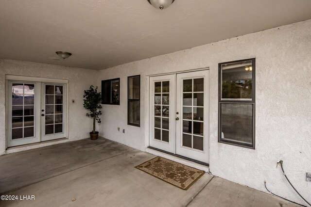 view of exterior entry with french doors and a patio area