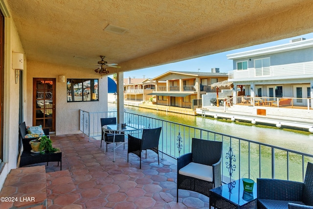 balcony featuring ceiling fan and a water view